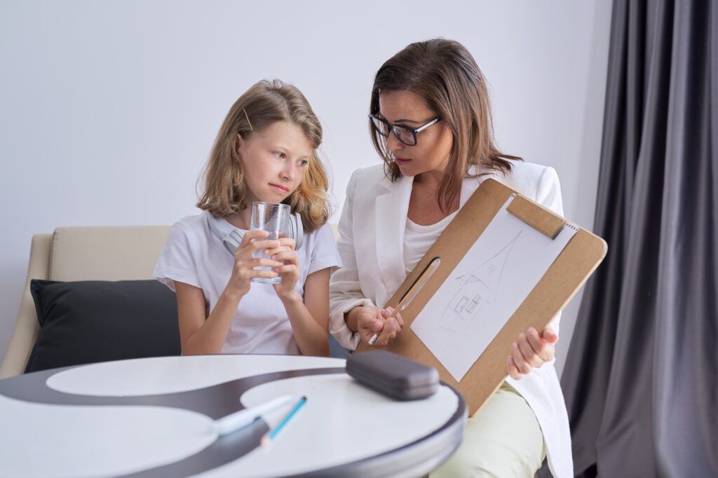Professional counseling for children, psychologist looks at childs drawing